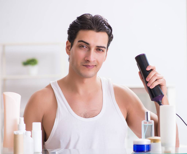 Jeune homme sèche ses cheveux le matin - Photo, image