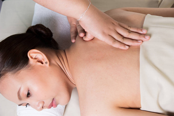 Massaggio del corpo sulla schiena nuda specifica della donna asiatica premendo le dita sul dolore o lo stress punto muscolare per rilasciare rilassarsi. Terapista Spa massaggio corpo donna mani trattamento sul cliente
 - Foto, immagini