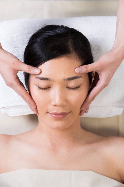 Ayurvédikus fejmasszázs terápia arc homlokon Master Chakra Point ázsiai nő, Terapeuta Spa test nő kezét kezelés az ügyfél, hogy növelje a vérkeringést felszabadító feszültség stressz gondolkodás munka - Fotó, kép