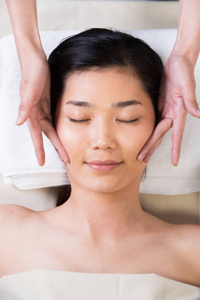 Ayurvedic Head Massage Therapy on facial forehead Master Chakra Point of Asian woman, Therapist Spa body woman hands treatment on customer to increase circulation release tension stress of think work - Foto, imagen