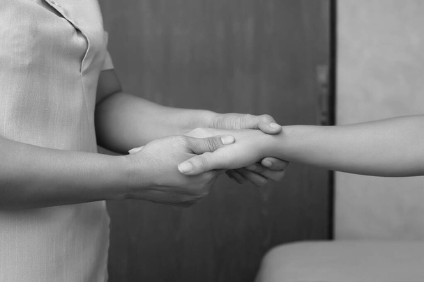 Profesjonalny azjatycki terapeuta skręcić i masaż spa na rękę klienta, aby uwolnić stres zrelaksować ból mięśni lub kontuzji. Fizjoterapeuta naciskający kciuk na konkretne miejsca dłoni żeńskiej - Zdjęcie, obraz