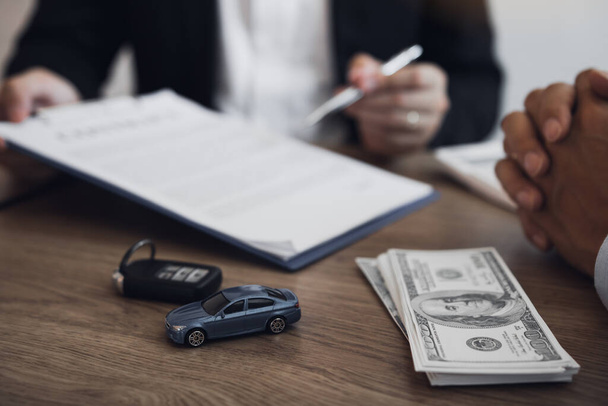 Agente venditore di auto sta spiegando circa il nuovo contratto di acquisto di auto e l'accordo con l'acquirente di auto
. - Foto, immagini