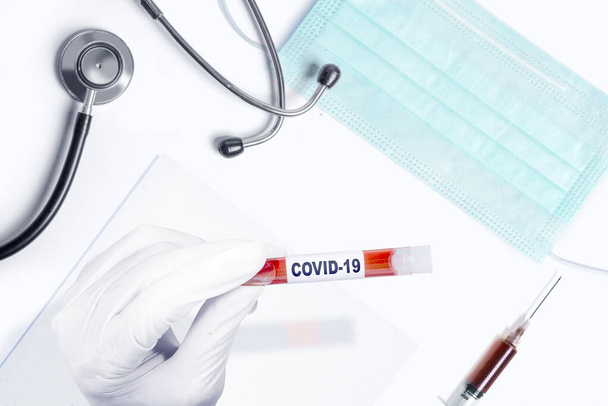 Doctor man in protective gloves holding a test tube with a coronavirus blood sample. Prevent flu disease Coronavirus - Φωτογραφία, εικόνα