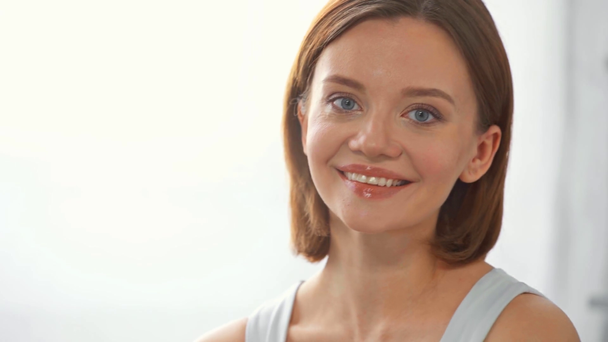 Vonzó fiatal nő mosolyog a kamera fehér háttér - Felvétel, videó
