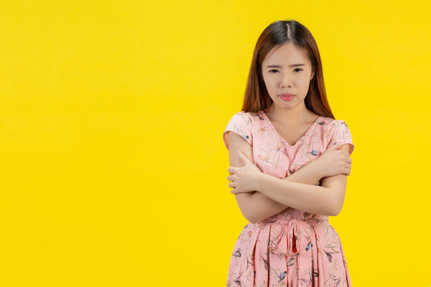 woman hugging herself on a yellow background - Foto, Imagen