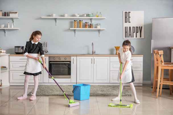 Niedliche kleine Zimmermädchen putzen Küche - Foto, Bild