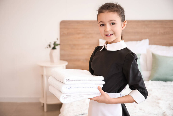 Linda camarera con toallas limpias en el dormitorio
 - Foto, imagen