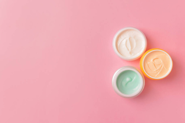 Jars of cosmetic cream on color background - 写真・画像