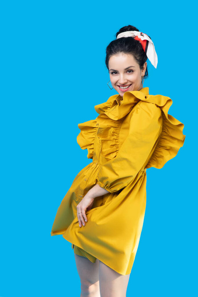 Young woman in a mustard dress looking romantic - Foto, imagen