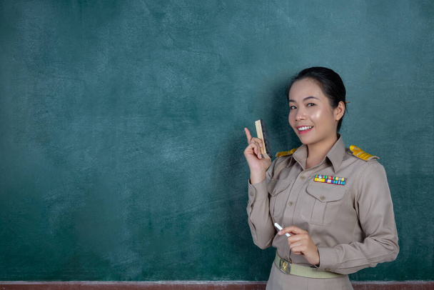 felice insegnante thai in abito ufficiale che agisce di fronte al backboard - Foto, immagini