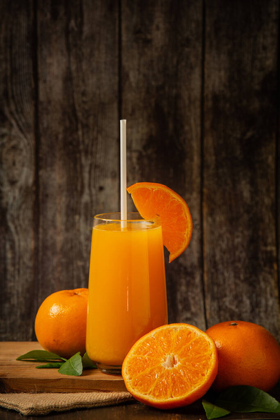 Čerstvý pomerančový džus ve sklenici a čerstvý pomeranč - Fotografie, Obrázek