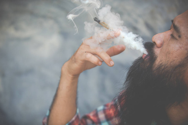 Ein Mann mit Schnurrbart, der Marihuana raucht, schöner Rauch, Cannabi - Foto, Bild