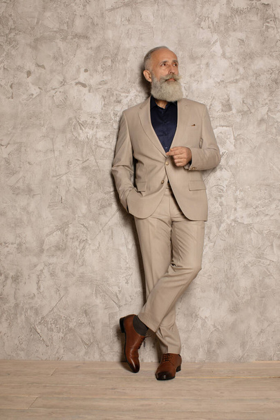 Portrait of mature businessman in suit standing on grey background. Copy space. - Foto, Bild