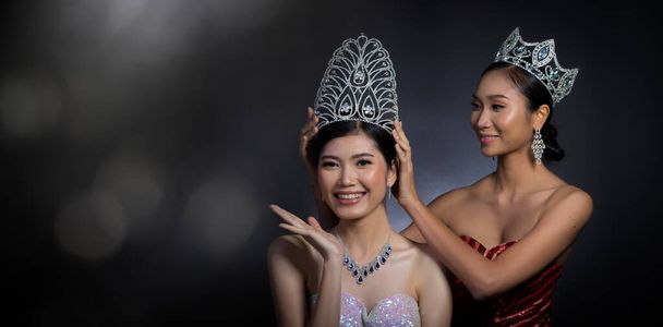 Last year winner Miss Beauty Pageant Contest put Diamond Crown on Final Winner latest year Miss Beauty Queen Pageant Contest with feeling wow smile glad face expression, two asian women moment session - Photo, Image