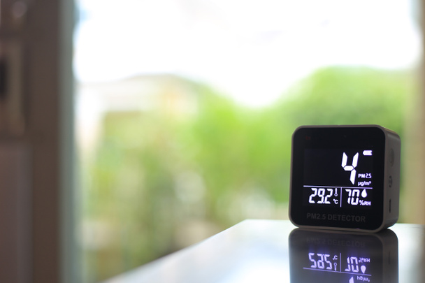 air quality sensor placing on a table indoor. sensor found small amount of air pollution of PM 2.5 the poisonous harmful particulate matter invisible dust from open field fire. man-made disasters. - Photo, Image