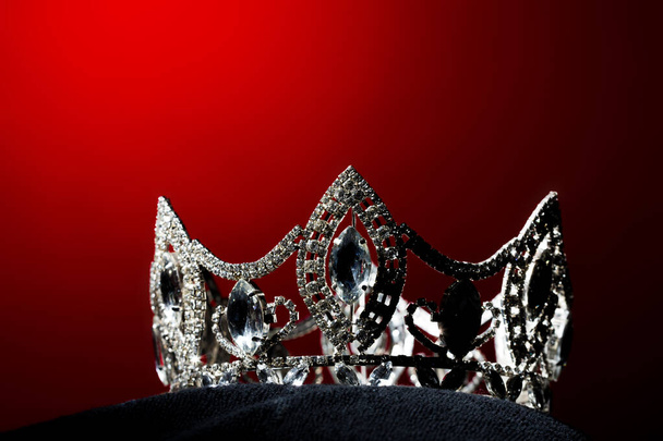 Silver Diamond Crown of Miss Pageant Beauty Universe World Contest sparkle light on black pillow, ready for wear Most beautiful Winner, studio lighting super red gradient background dramatic - Foto, immagini