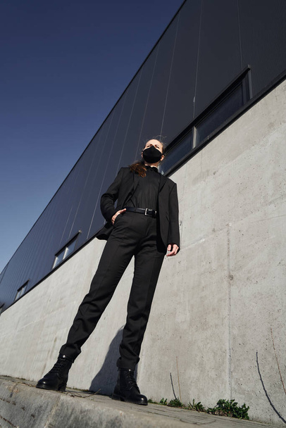 Young girl in a black protective mask and black sunglasses on the street, protecting against the virus - Foto, afbeelding