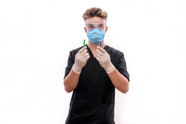 Химик с пробирками в защитной форме изолирован на белом. Молодой человек в очках, маске и перчатках  - Фото, изображение