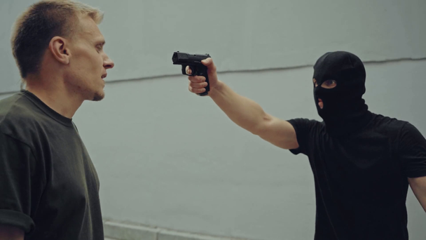 gangster in maschera cielo puntando con pistola e combattendo con l'uomo
 - Filmati, video