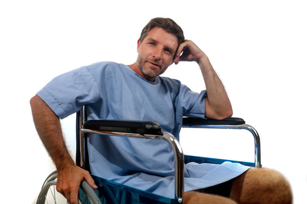 isolated portrait of young attractive happy and positive hospital patient man in wheelchair smiling hopeful recovering of virus infection or health problem healing the pain feeling cured - Zdjęcie, obraz