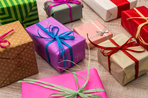 Bunte Geschenkboxen auf hölzernen Tischplatten. Geschenke, Neujahr und Weihnachtsfeier - Foto, Bild