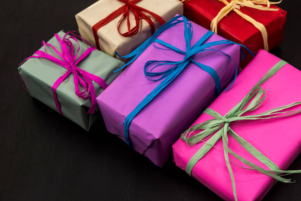 Colorful gift boxes on dark background. Celebration of new year and Christmas  - 写真・画像