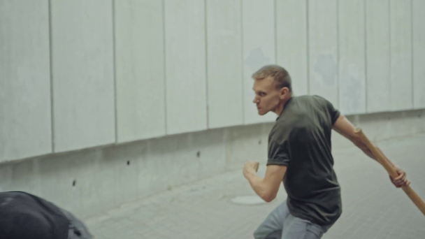 deux hommes avec des battes de baseball se battant près de murs en béton
  - Séquence, vidéo