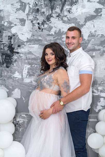 Waiting for a baby. Amazing pair husband and pregnant wife posing in studio - Photo, Image