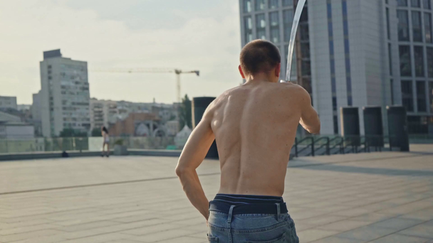 shirtless man in denim jeans sword dancing on rooftop  - Séquence, vidéo