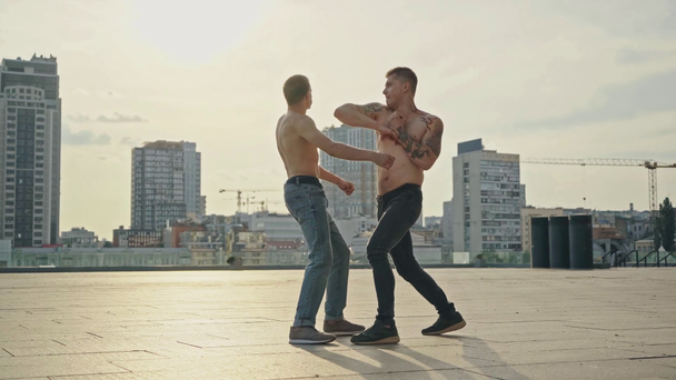 μυώδεις και γυμνοί άνδρες που μάχονται στην ταράτσα   - Πλάνα, βίντεο