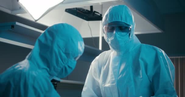Naukowcy badający próbkę koronawirusu w laboratorium - Materiał filmowy, wideo