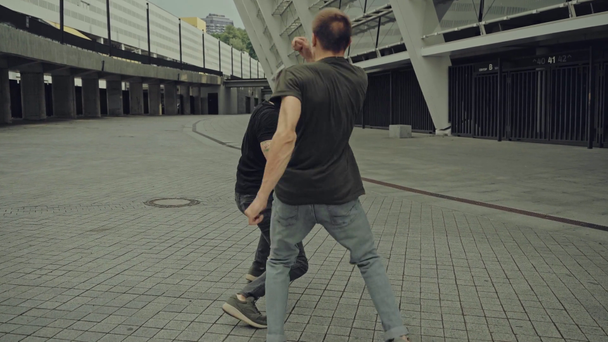 przystojny mężczyźni walki na ulicy w pobliżu budynek  - Materiał filmowy, wideo