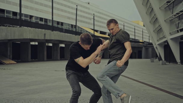 starker Mann schlägt tätowierten Kämpfer auf Straße  - Filmmaterial, Video