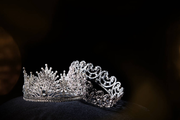 Diamentowa srebrna korona na konkurs piękności Miss, biżuteria Crystal Tiara zdobione kamienie szlachetne i abstrakcyjne ciemne tło na tkaniny z czarnego aksamitu, makro fotografia kopiuj miejsce na logo tekstu - Zdjęcie, obraz