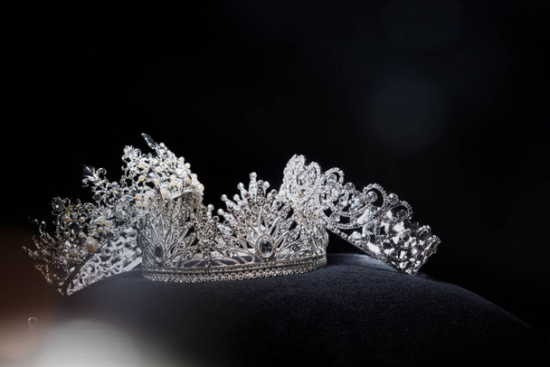 Diamond Silver Crown for Miss Pageant Beauty Contest, Crystal Tiara jewelry decorated gems stone and abstract dark background on black velvet fabric cloth, Macro photography copy space for text logo - Fotografie, Obrázek
