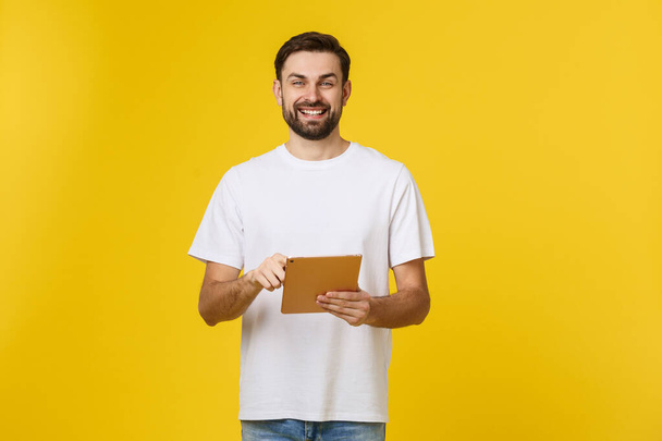 Happy Young Man za pomocą tabletu cyfrowego izolowane na żółtym tle - Zdjęcie, obraz