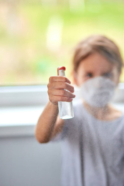 Bambina indossare maschera igienica e premere spray alcol per proteggere, sanificante. Coronavirus, covid-19 e concetto di protezione dell'inquinamento. Resta a casa.. - Foto, immagini
