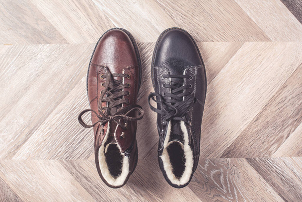 Black and brown colors of shoes on wooden background. Sale and shopping concept. Copy space. Banner. Classic winter warm fashion male shoes. - Fotó, kép