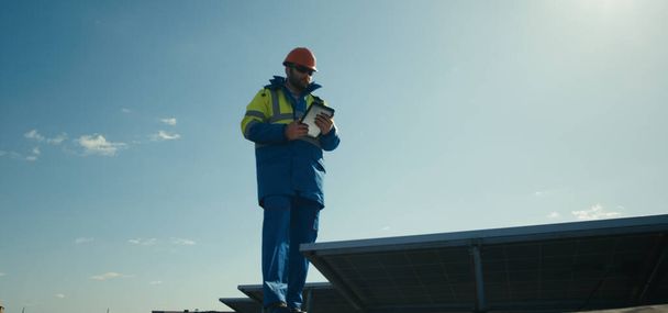 Techniker läuft neben Solarzellen - Foto, Bild