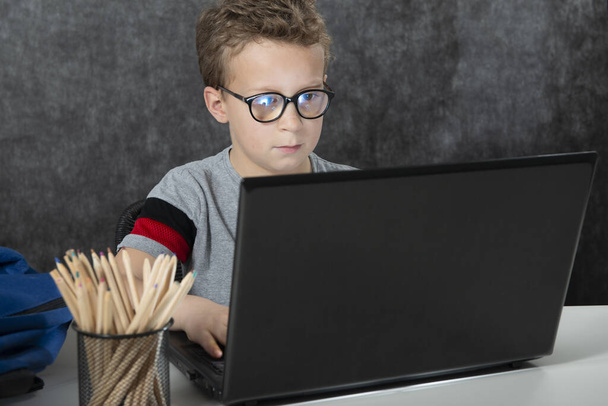 serious boy sitting with a laptop computer - 写真・画像