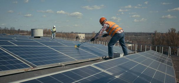 Technicien nettoyage panneaux solaires sur toit plat
 - Photo, image
