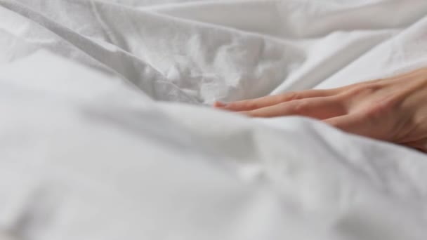 hand van de vrouw knijpen wit beddengoed of deken - Video