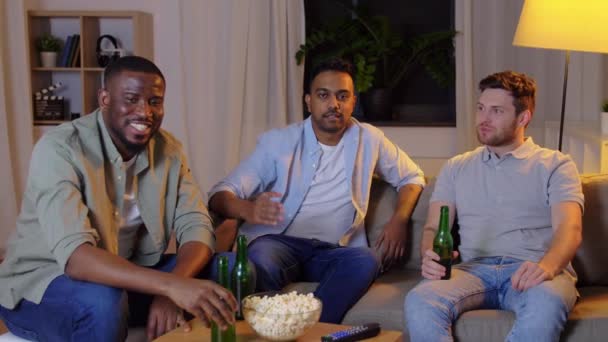 happy male friends with beer watching tv at home - Filmagem, Vídeo