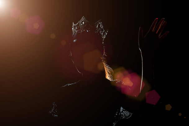 Retrato Silueta Sombra Volver Borde Luz de Miss Desfile Belleza Reina Concurso Plata Diamante Corona onda mano expresar sensación sonrisa, estudio iluminación fondo negro oscuro, gire frente a la cámara
 - Foto, Imagen