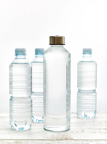 再充填可能なガラス水ボトルと単回使用のプラスチックボトルとのゼロ廃棄物の概念 - 写真・画像