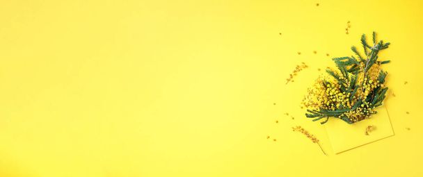 Sarı zarf ve bahar çiçekleri. Kadınlar Günü için Mimosa hediyesi. Çiçek kompozisyonu, yaratıcı tasarım. Düz yerde, üst tarafta. Bahar, yaz veya bahçe konsepti. - Fotoğraf, Görsel