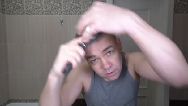 unshaven man morning in bathroom styling comb hair - Záběry, video