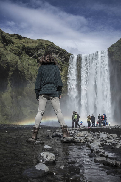 A young woman at Skogafoss waterfall in the golden circle of Iceland - Fotografie, Obrázek
