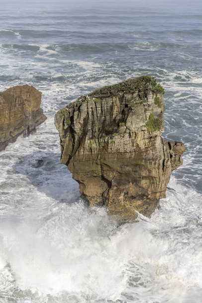 τοπίο με μεγάλα κύματα συντριβή σε φθαρμένο βράχο στην ακτή της θάλασσας Tasman, πυροβόλησε σε έντονο φως άνοιξη στο Punakaiki Pancake Rocks Park, Δυτική Ακτή, South Island, Νέα Ζηλανδία - Φωτογραφία, εικόνα
