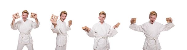 Legrační karate muž lámání cihel izolovaných na bílém - Fotografie, Obrázek